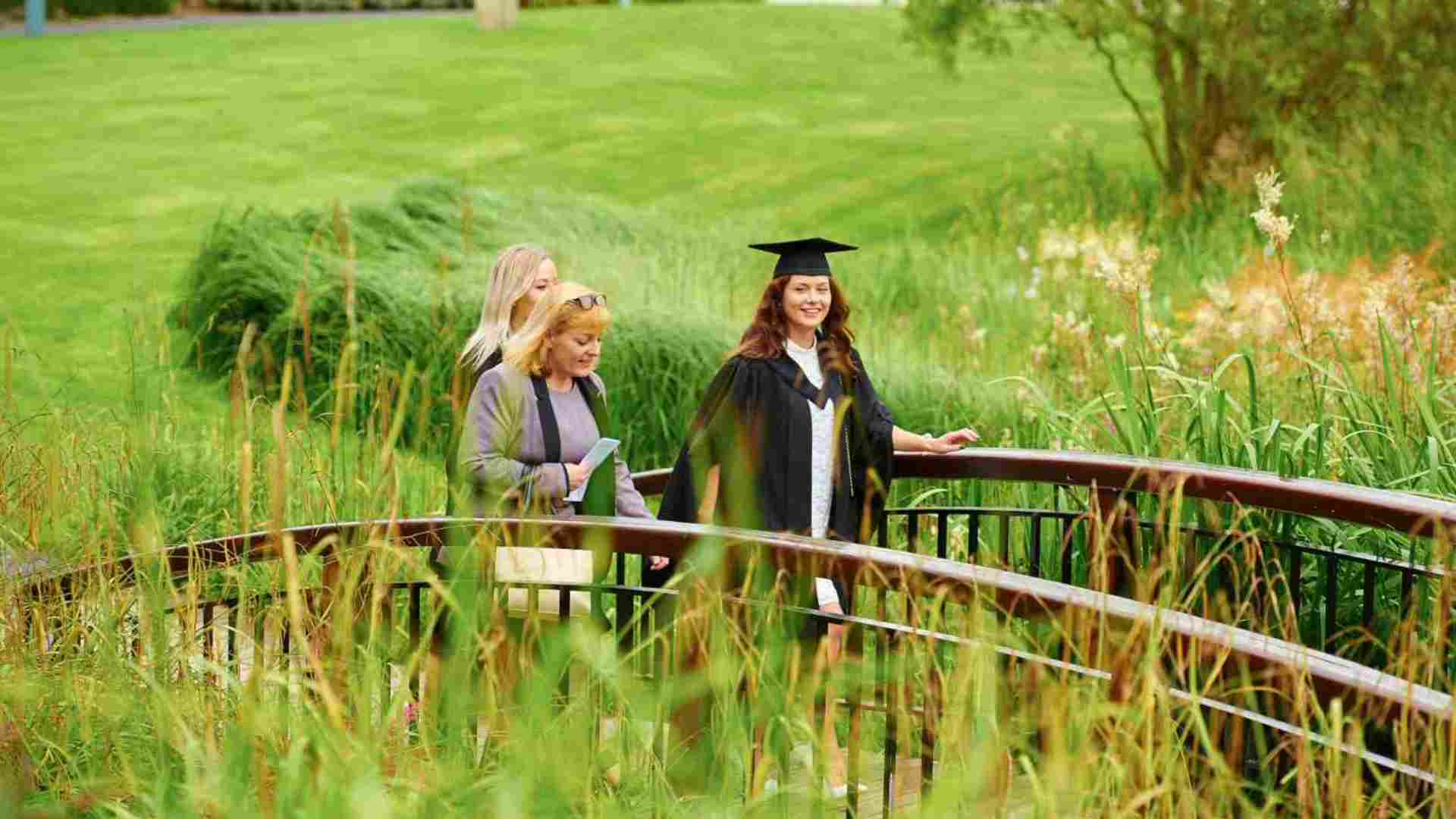 Graduate walking over lake